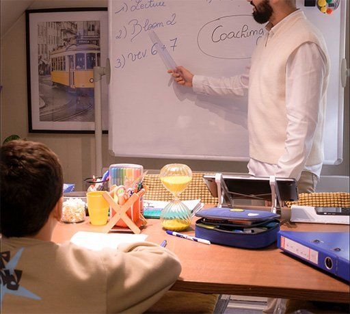 Mansour au tableau blanc pendant une séance de coaching individuel avec un élève